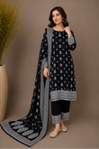 Woman wearing a black and white patterned outfit with a matching dupatta against a brown background