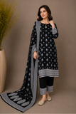 Woman wearing a black and white patterned outfit with a matching dupatta against a brown background