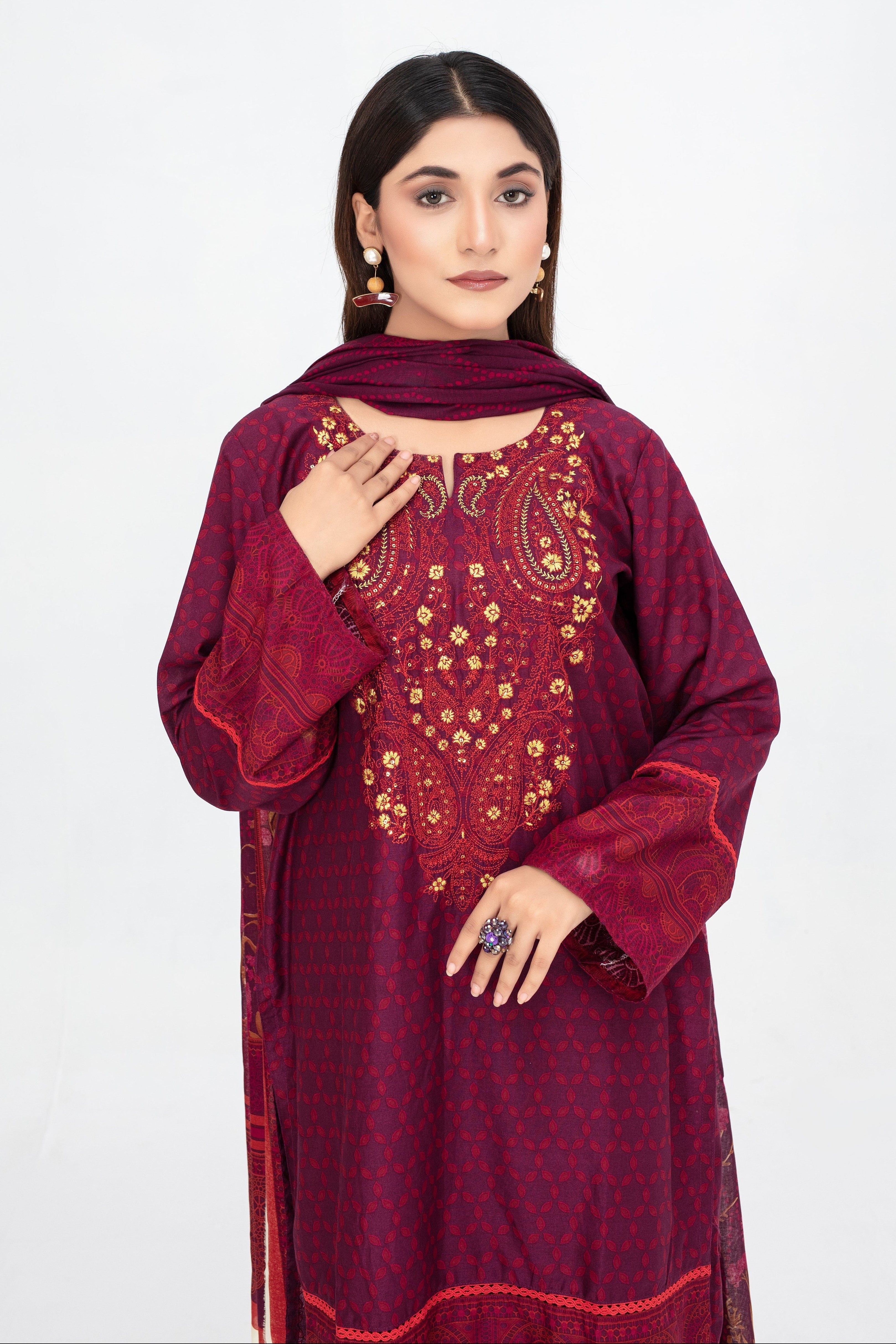 Woman wearing a maroon embroidered traditional outfit on a white background